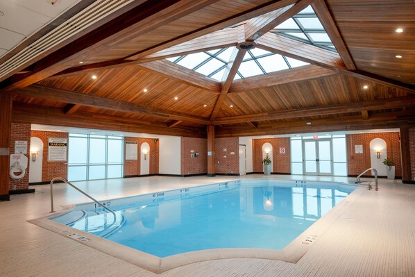 An indoor swimming pool with a wooden ceiling and brick walls. - Sleepy Hollow Hotel, a Dolce by Wyndham (Tarrytown)