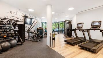 A modern gym with treadmills, exercise balls, and kettlebells.
