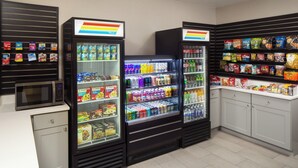 A self-service beverage station with refrigerated drink dispensers and snack vending machines. - Holiday Inn Weirton - Steubenville Area by IHG (Weirton)