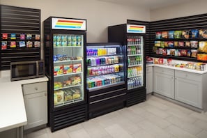 Un espace de libre-service proposant des boissons, avec des distributeurs réfrigérés et des distributeurs automatiques de collations.