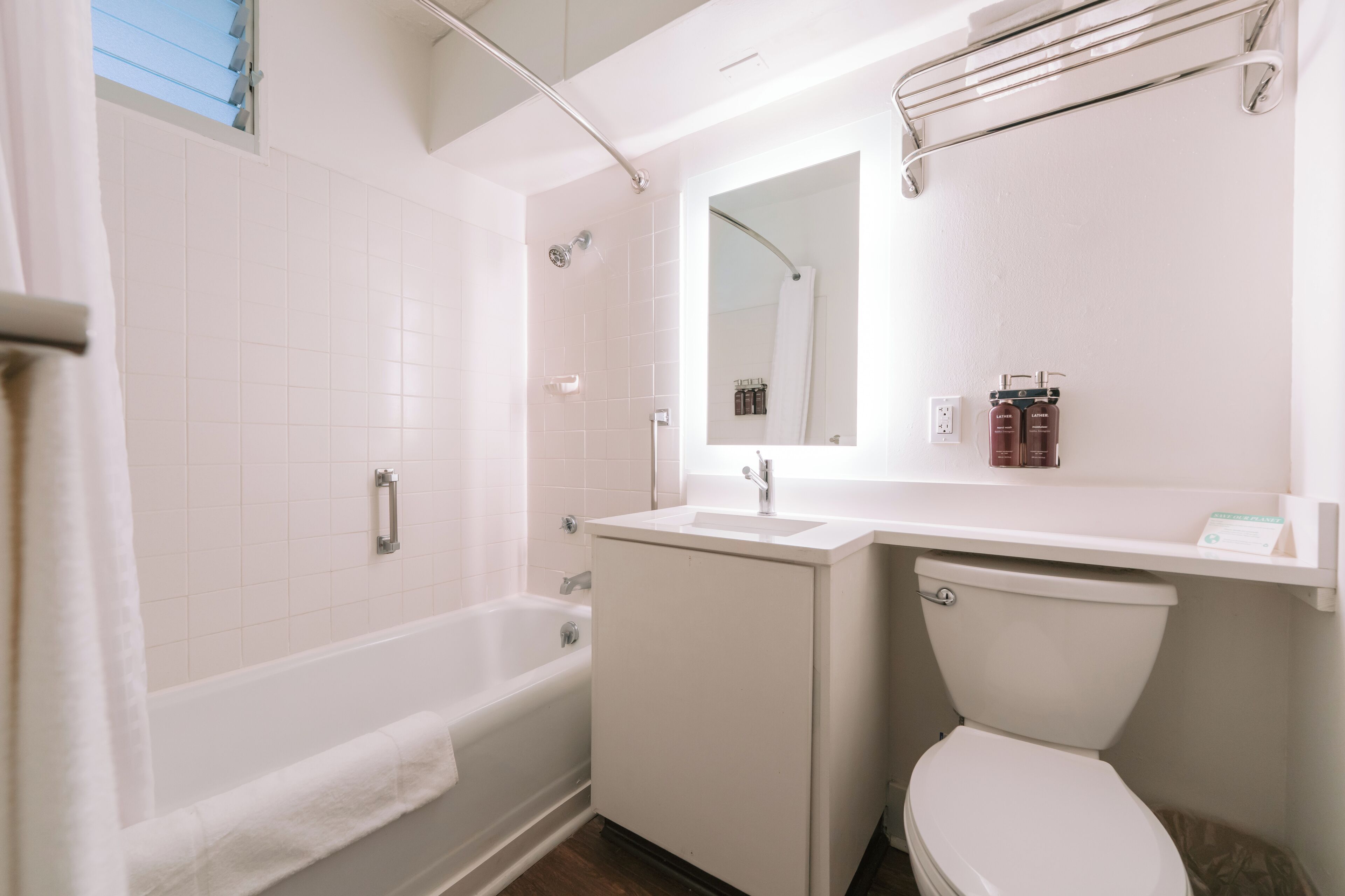 Ein Badezimmer mit Badewanne, Toilette, Waschbecken und Spiegel.