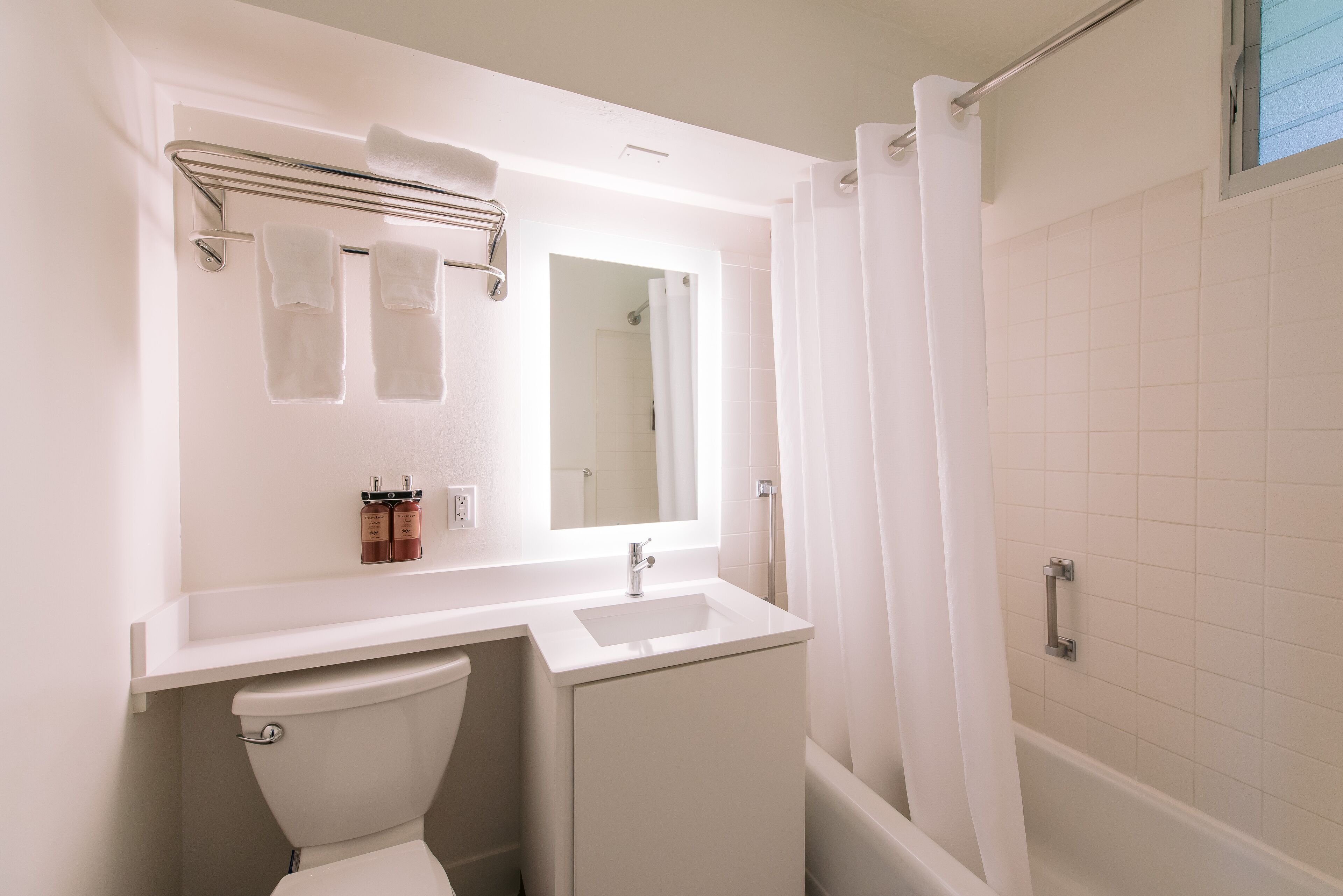 A bathroom with a toilet, sink, and shower area.