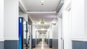 A long, narrow hallway with wooden flooring and white walls. - Baymont by Wyndham Bellingham (Bellingham)