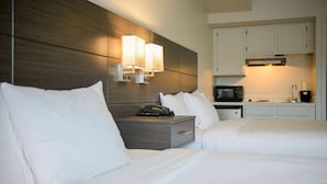 A hotel room with two beds, a bedside table with a telephone, and a microwave in the kitchenette area. - Baymont by Wyndham Bellingham (Bellingham)