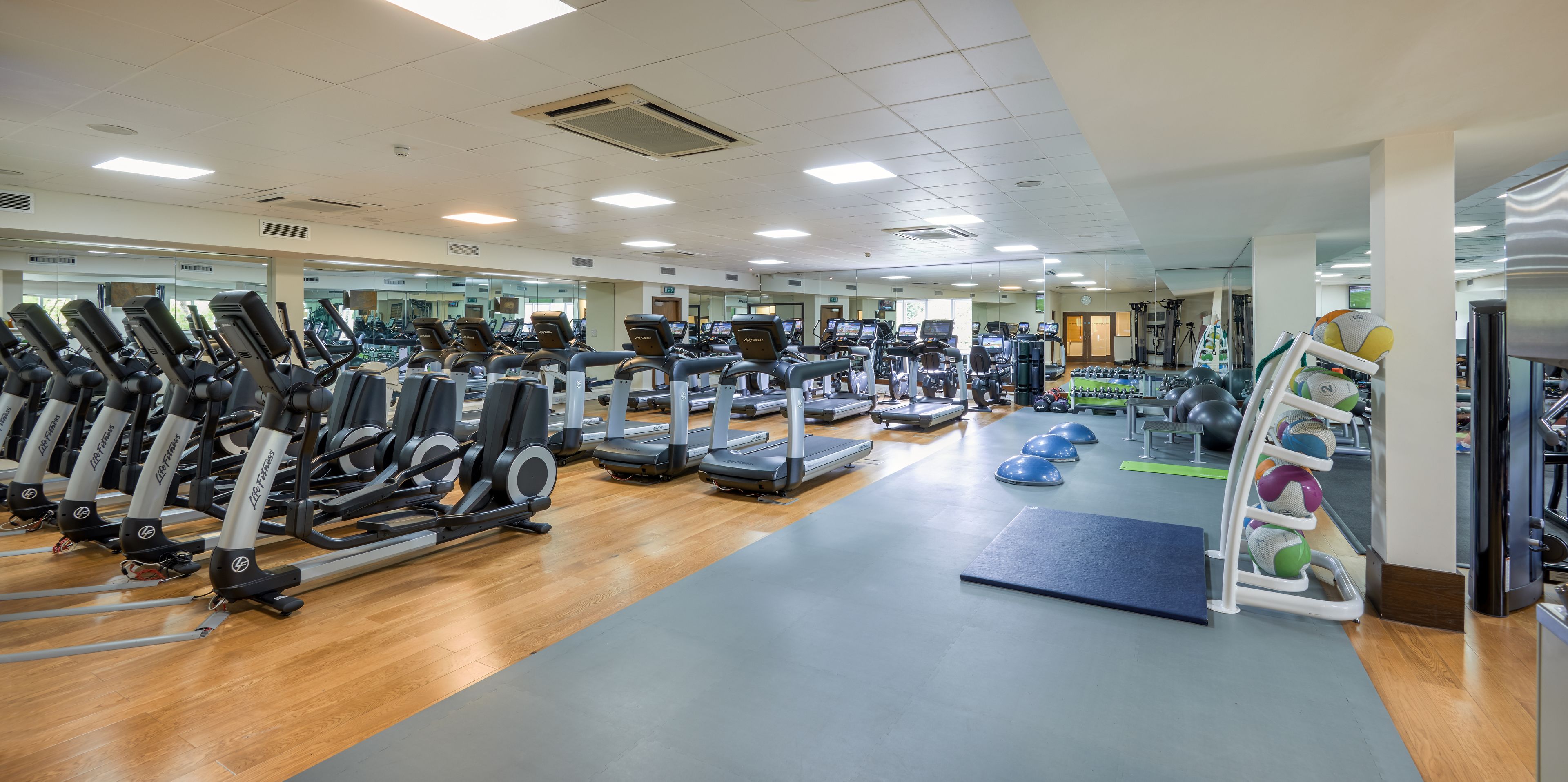 A gym with cardio equipment, weight machines, and free weights.