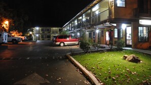 Un hôtel à plusieurs étages, doté d’un parking et d’un espace verdoyant parsemé de rochers.