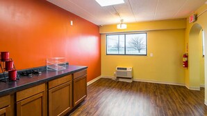 A room with wooden cabinets, a black countertop, and a window with a view of trees. - Econo Lodge South Holland - Chicago Southland (South Holland)