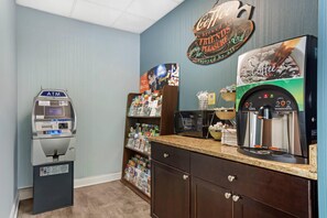 A coffee shop with an ATM, a coffee machine, and a shelf with various items. - Quality Inn Old Saybrook - Westbrook (Old Saybrook)