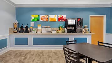 A kitchen area with a coffee machine, a fruit bowl, and a microwave.