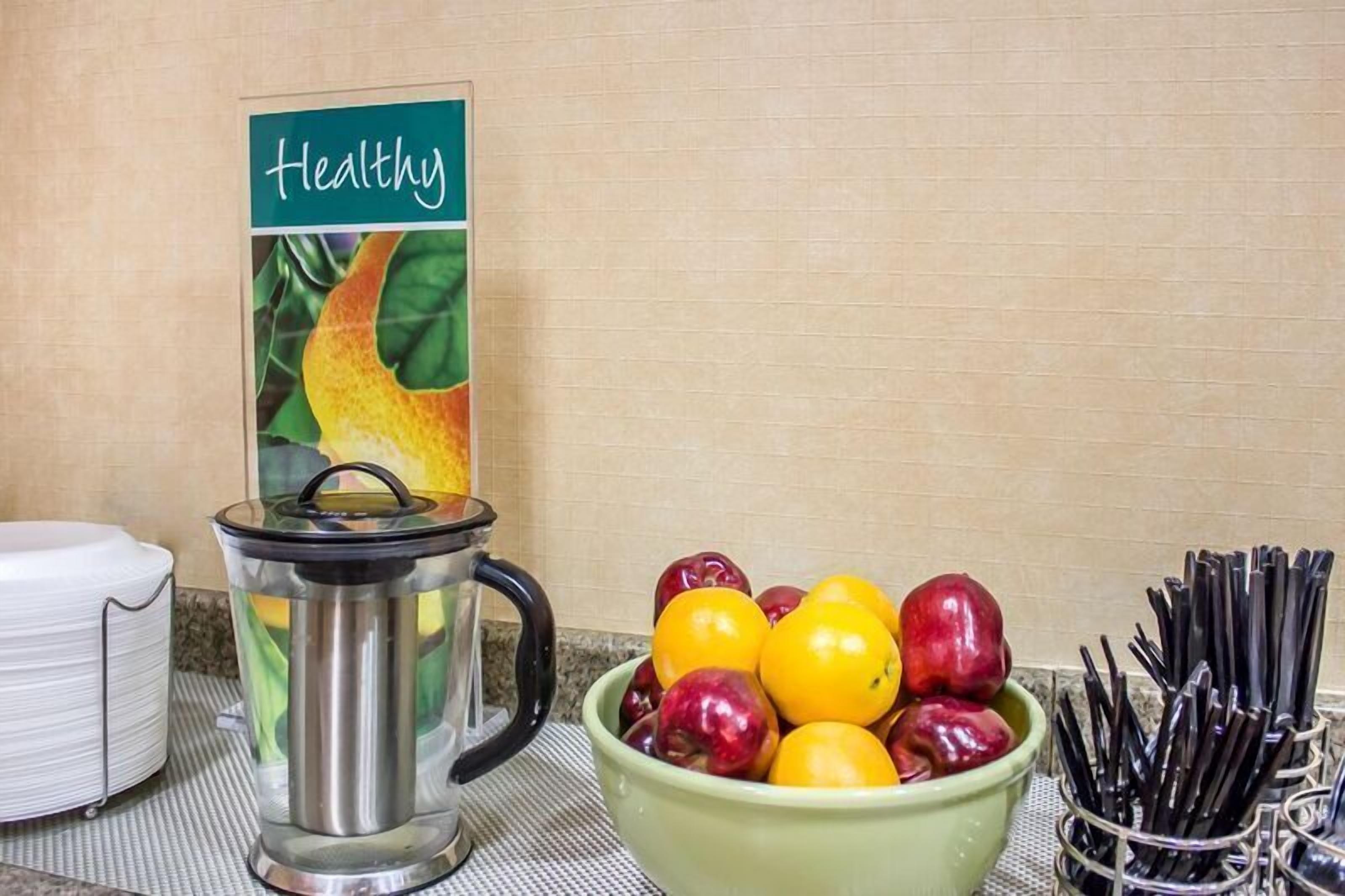 A kitchen counter with a fruit bowl, a kettle, and a sign labeled "Healthy."