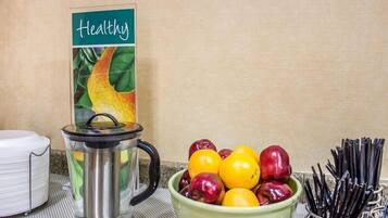 A kitchen counter with a fruit bowl, a kettle, and a sign labeled "Healthy."