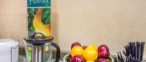 Una encimera de cocina con un frutero, una tetera y un letrero que dice 'Healthy'.