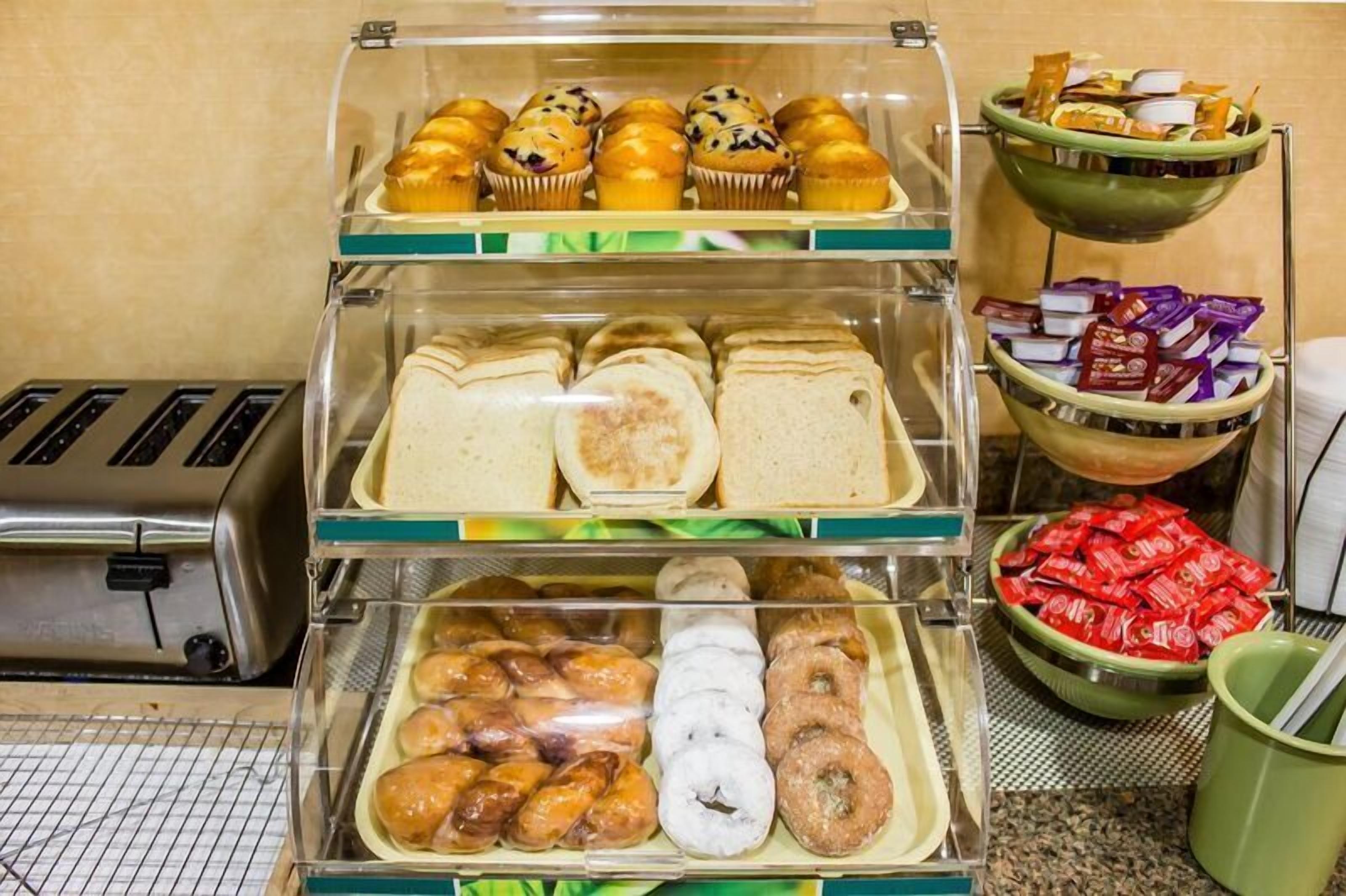 A breakfast display with muffins, sandwiches, and pastries.