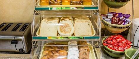 A breakfast display with muffins, sandwiches, and pastries.
