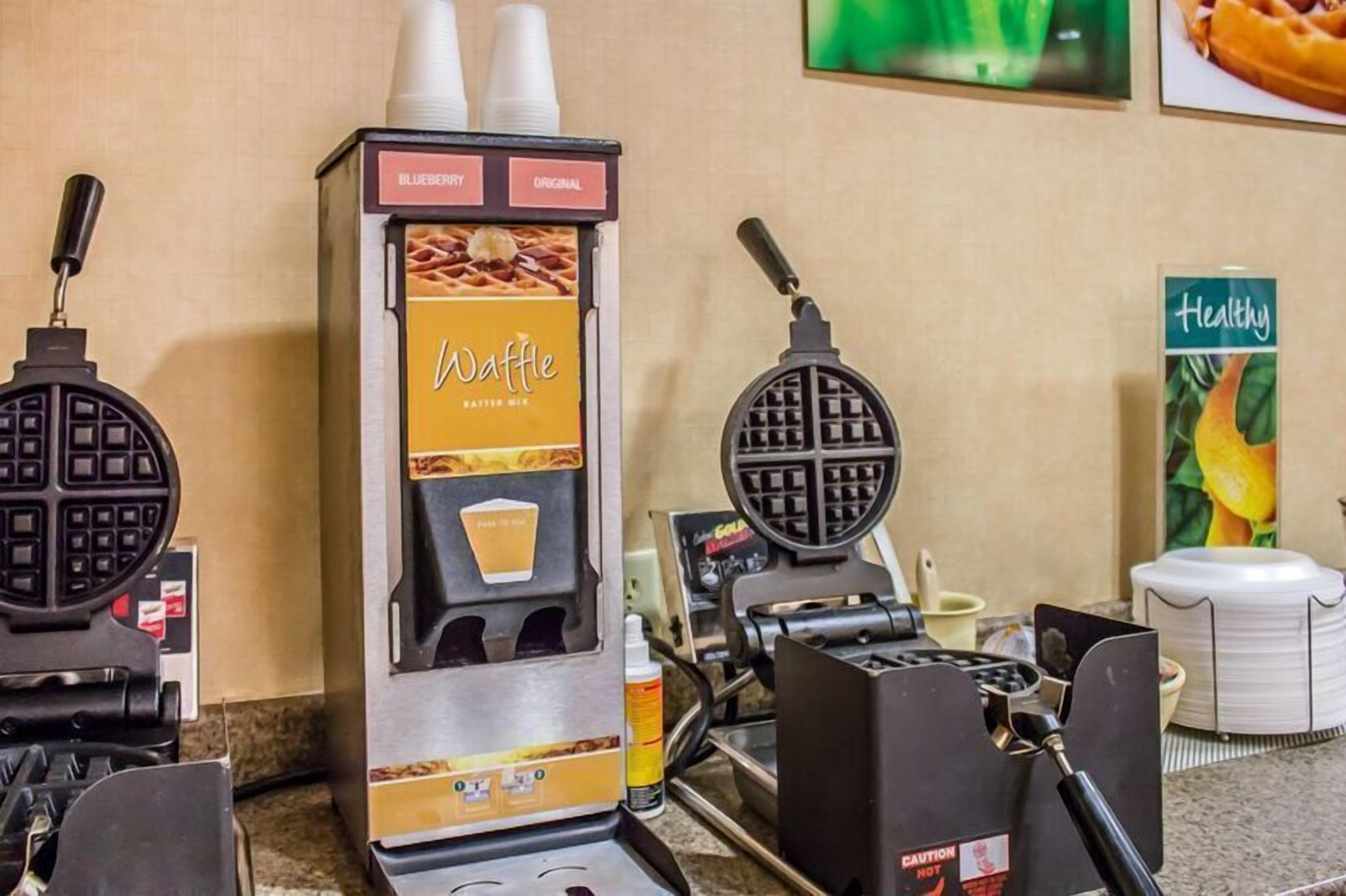 A waffle maker with a label for 'Blueberry Original Batter Mix' and a 'Healthy' sign in the background.