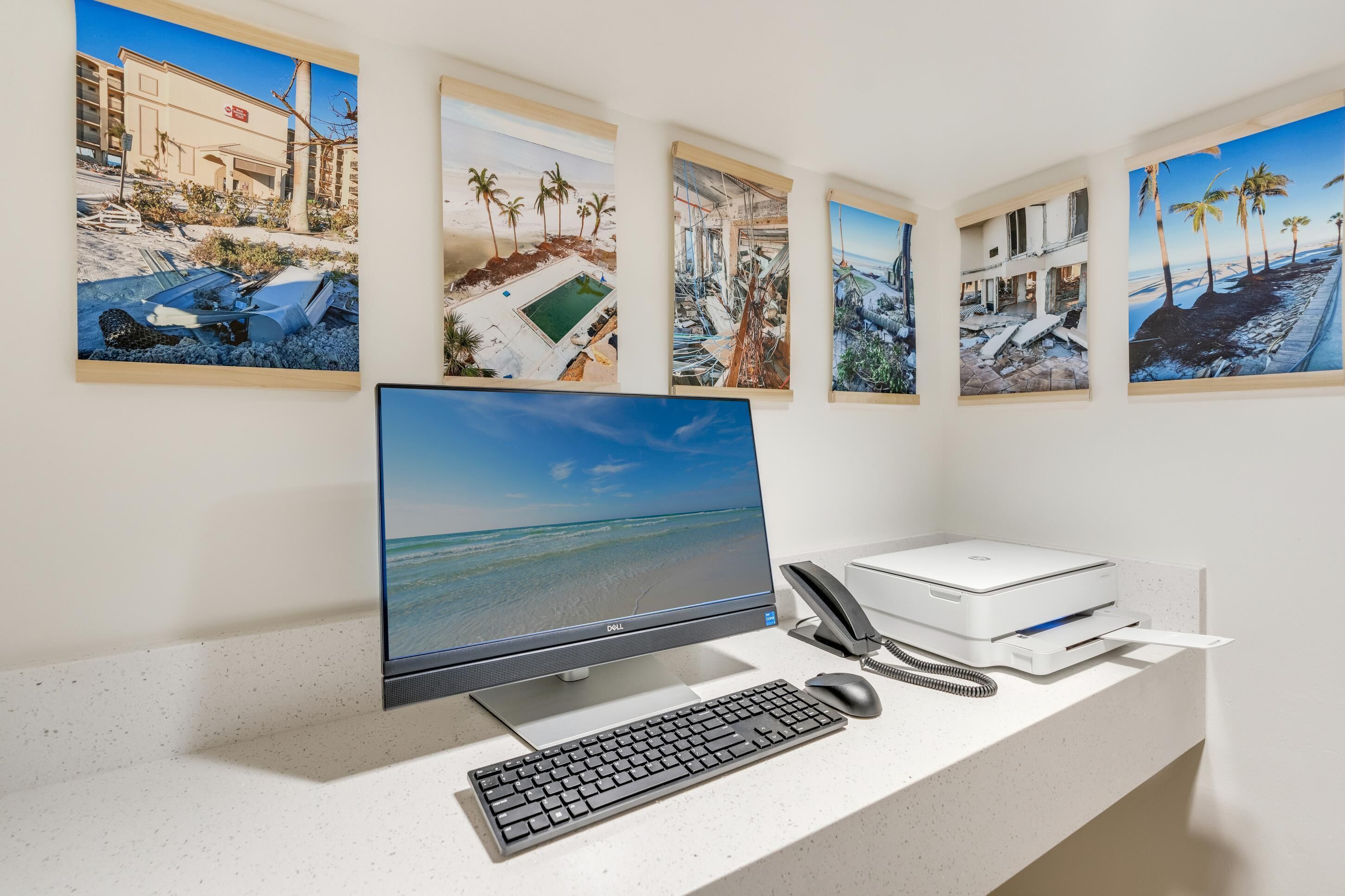 Un bureau avec un écran d’ordinateur, un clavier, une souris et une imprimante.