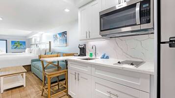 A modern kitchen with white cabinets, a built-in microwave, and a sink.