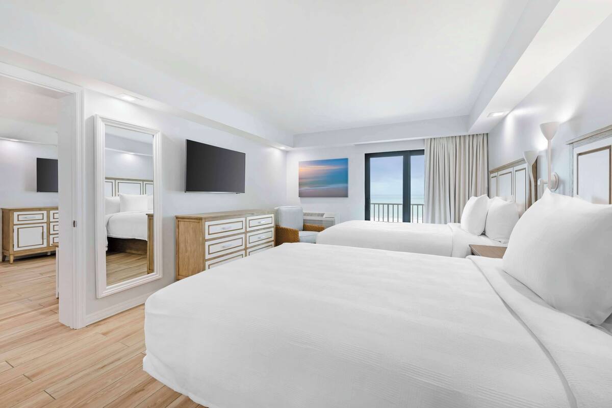 Una habitación de hotel moderna con una cama grande, un escritorio y un televisor.