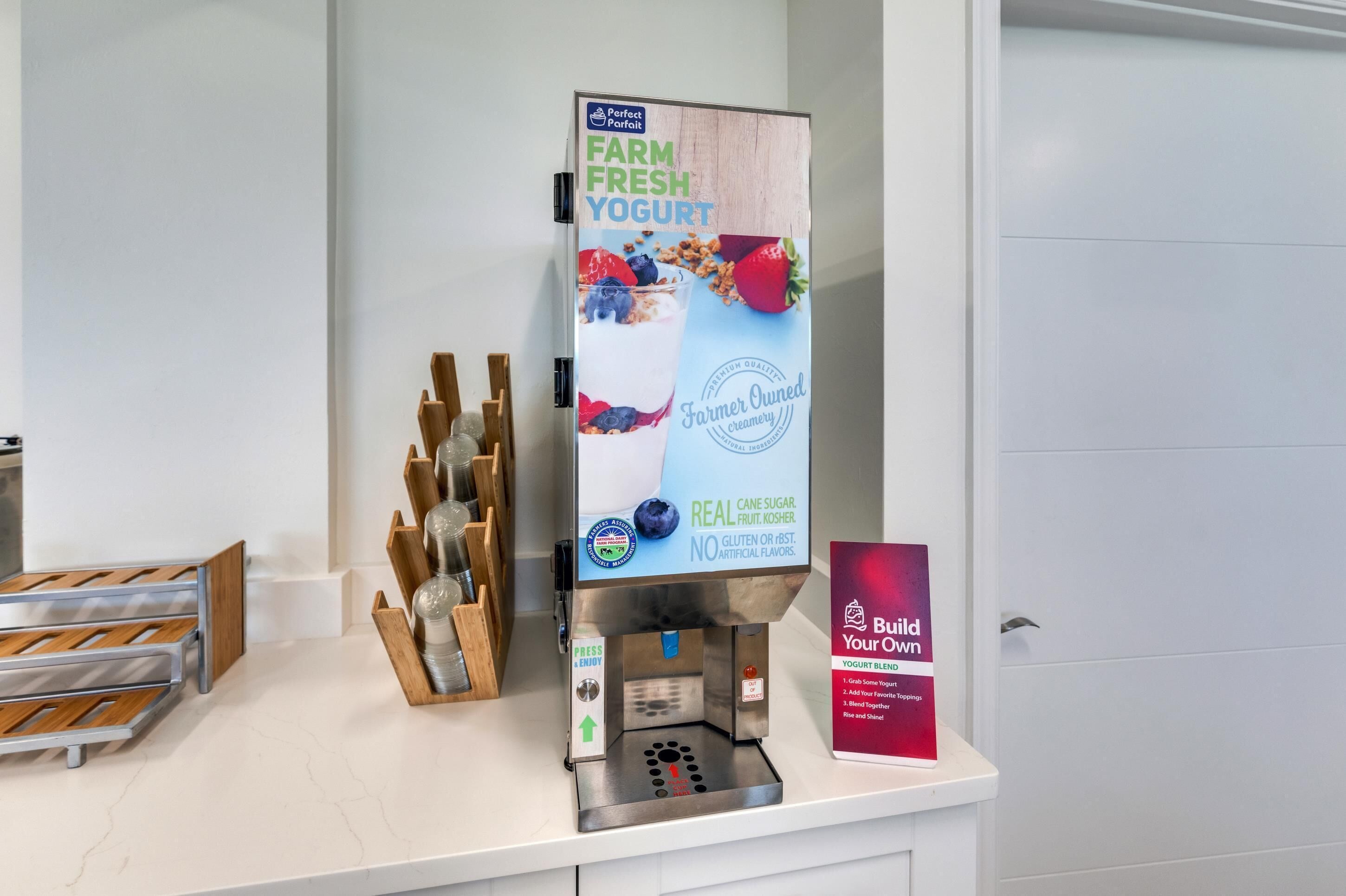 A yogurt dispenser with a sign advertising 'Farm Fresh Yogurt' and 'Real Cane Sugar, Kosher, No Gluten or Artificial Flavors'.
