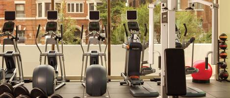 A gym with various exercise equipment, including treadmills, elliptical machines, and free weights.