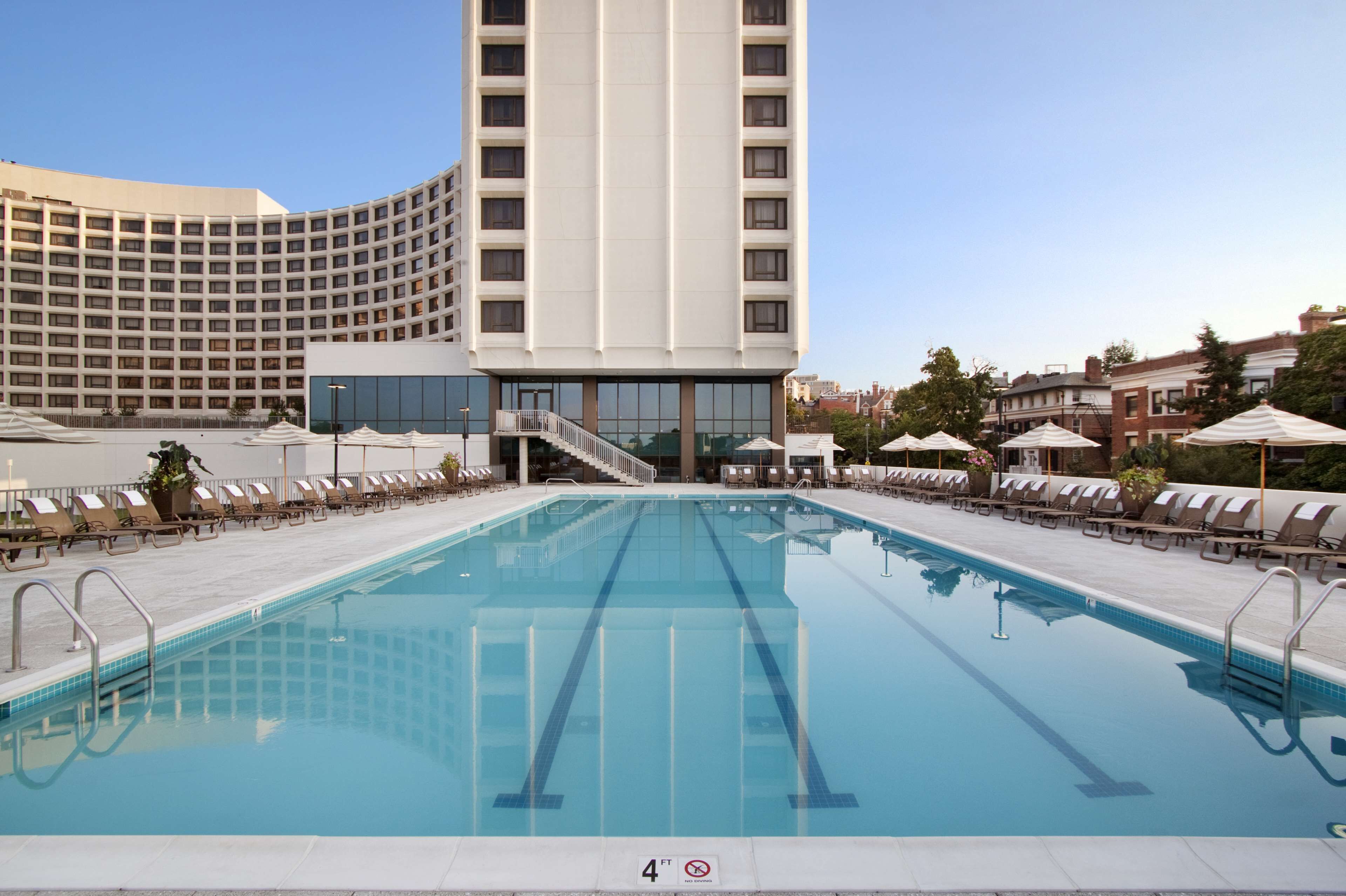 Una piscina al aire libre de temporada, sombrillas