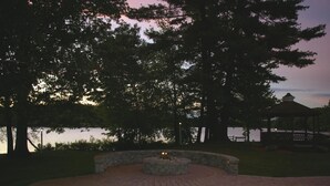 A circular brick patio with a fire feature, surrounded by trees and a gazebo. - Sturbridge Host Hotel & Conference Center (Sturbridge)