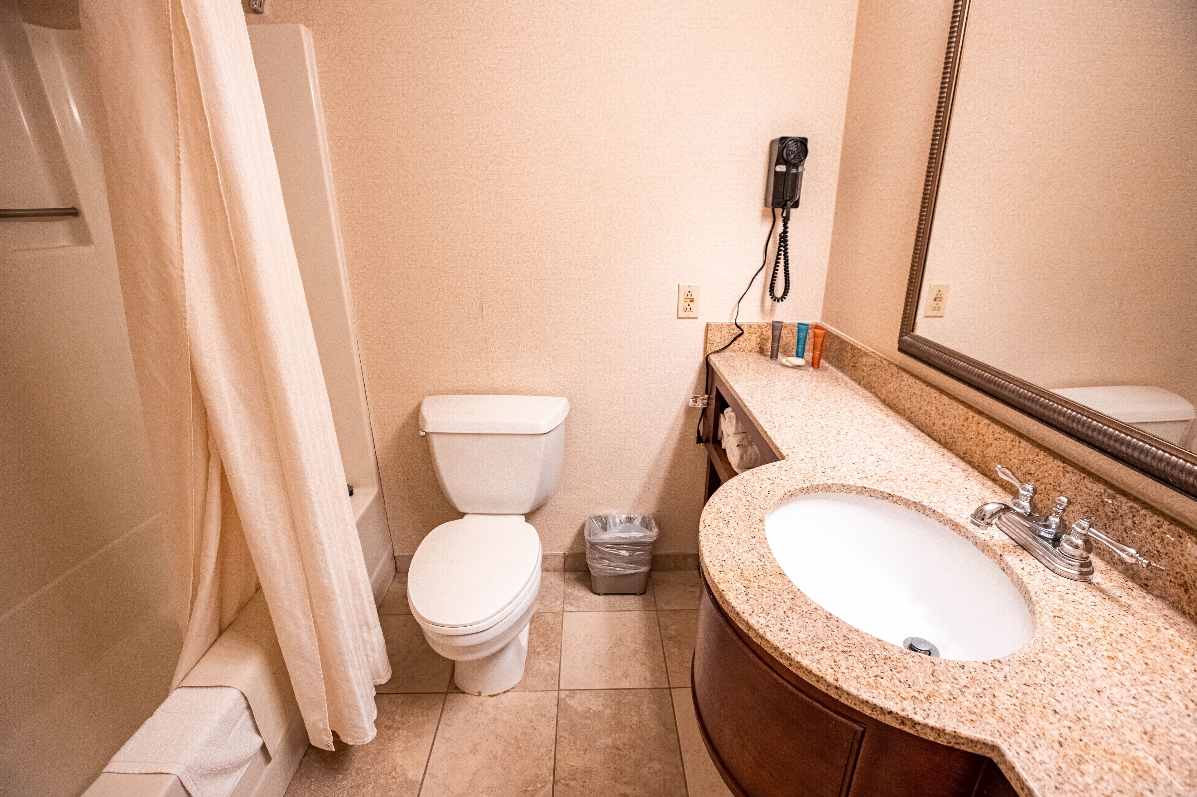 Un bagno con il water, un lavandino e una tenda da doccia.