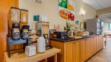 Um balcão de pequeno-almoço com cereais, café e opções de waffles, uma máquina de waffles e um frigorífico.
