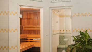 A sauna room with wooden benches and a glass door leading to a shower area.