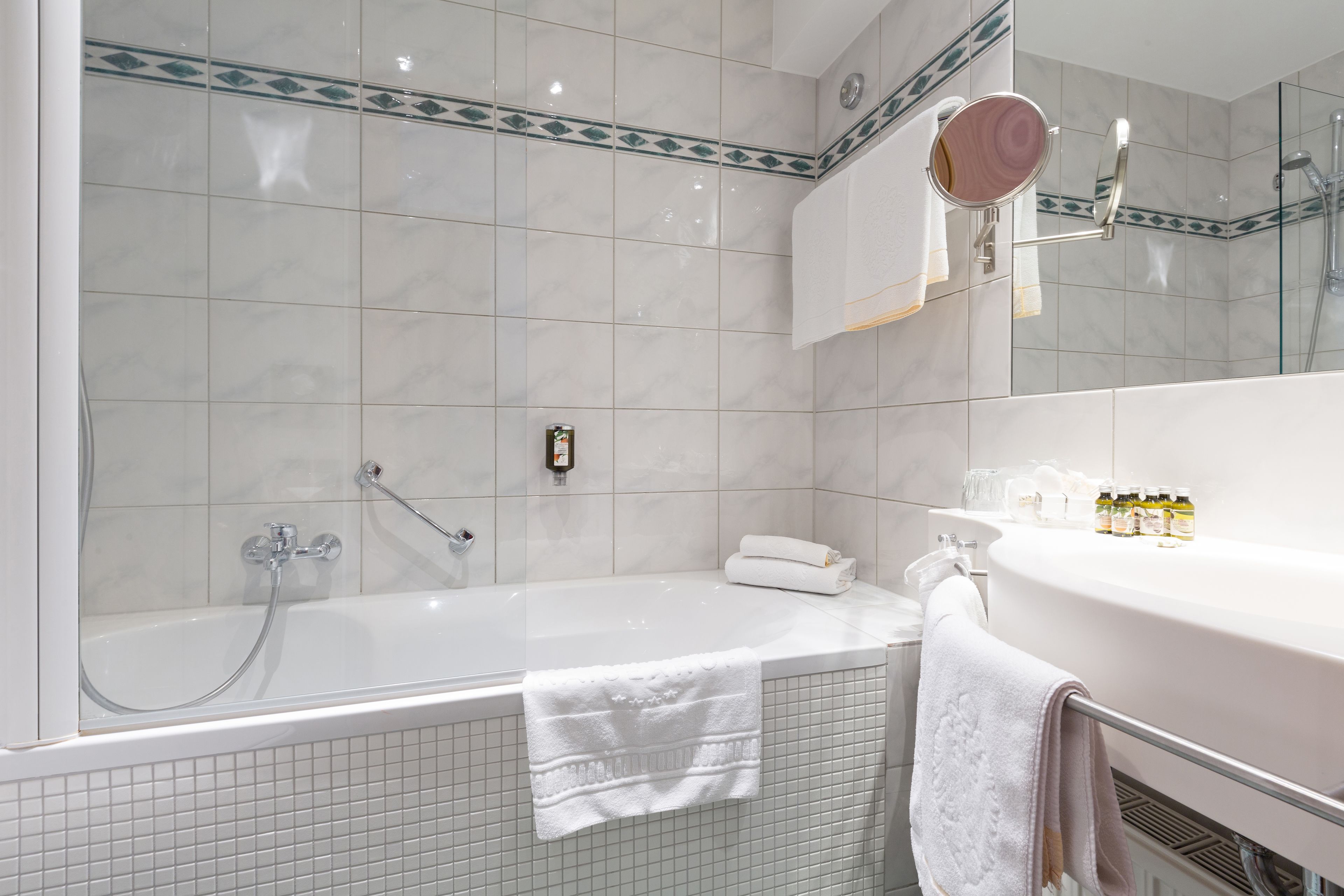 A modern bathroom with a bathtub, a sink, and a mirror.