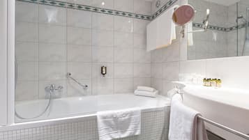 A modern bathroom with a bathtub, a sink, and a mirror.