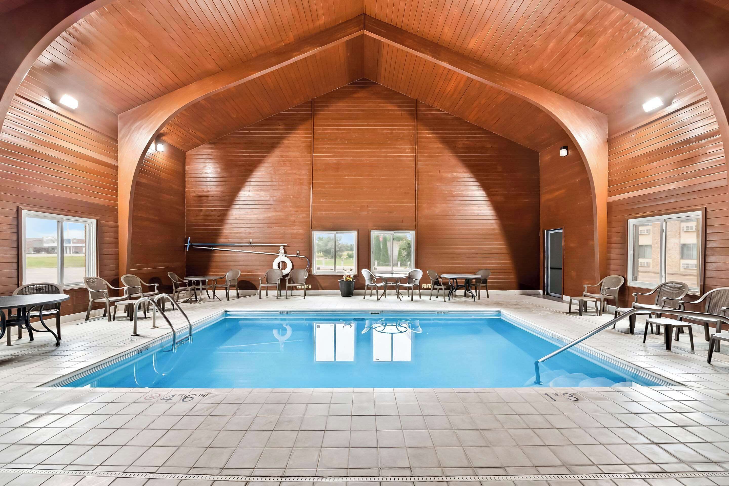 Una piscina techada, sillones reclinables de piscina