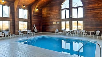 Una piscina techada, sillones reclinables de piscina
