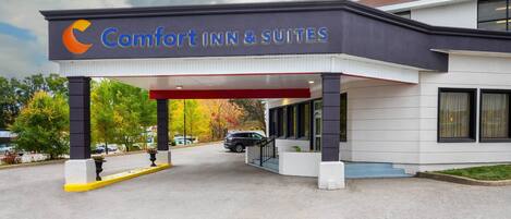A Comfort Inn & Suites with a covered entrance, a parking lot, and a building with large windows.