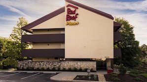 A two-story building with a sign reading 'Red Roof Plus'.