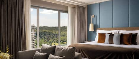 Une chambre d’hôtel avec un grand lit, un canapé et une vue sur le paysage urbain.