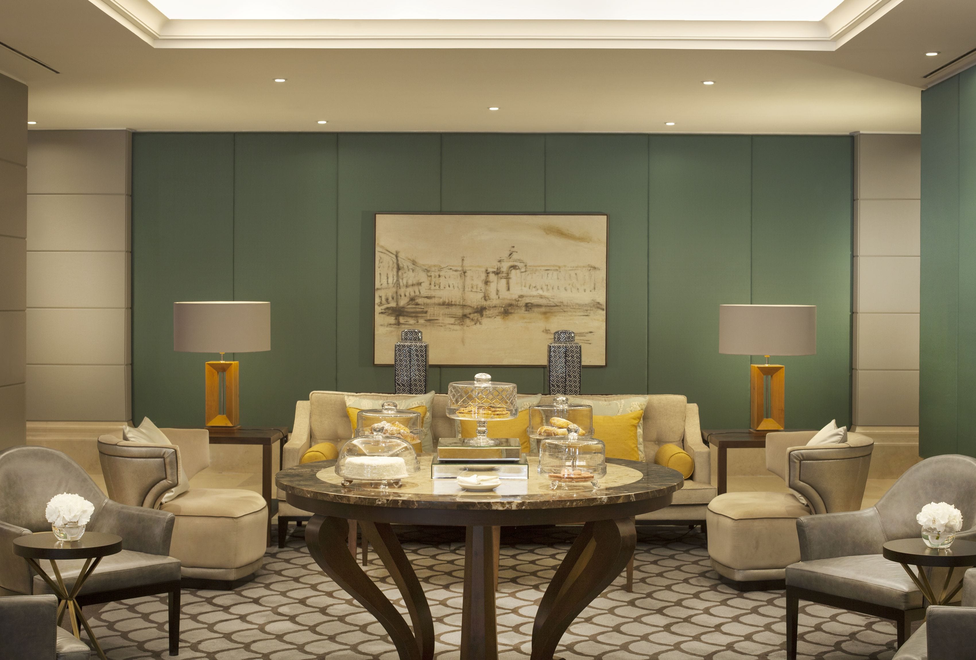 Una zona lounge moderna con un tavolo rotondo, sedute confortevoli e elementi decorativi.