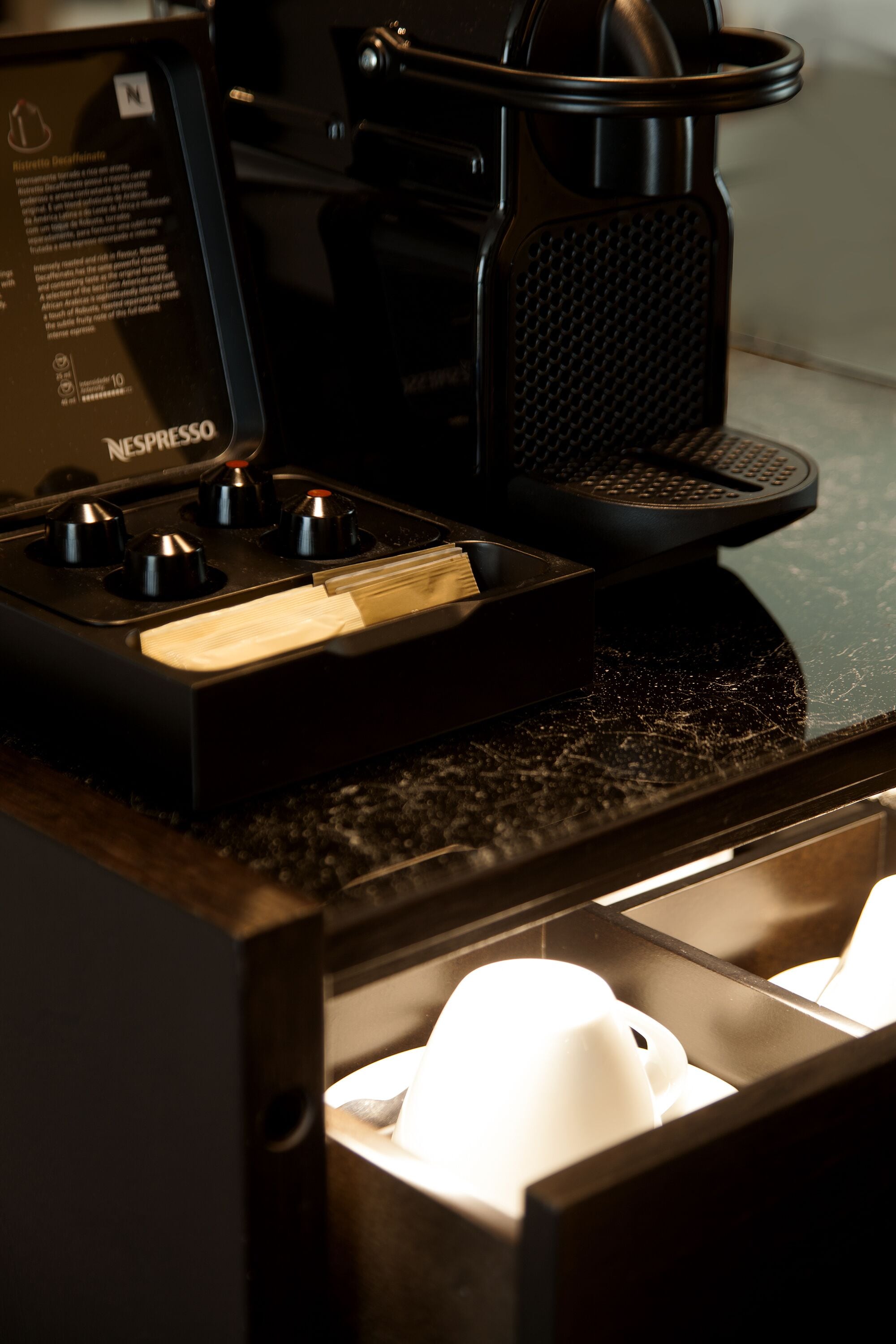 A Nespresso coffee machine with a drip tray and a coffee maker.