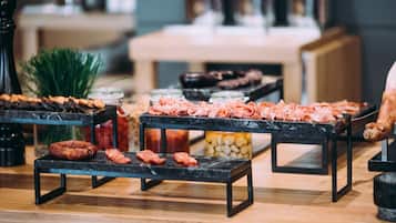 Uma mesa de buffet com diversos tipos de carne e queijos.