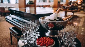 A table with champagne glasses, a bowl of strawberries, and a bottle of champagne in a bucket.