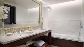 Un baño moderno con dos lavamanos, un espejo grande y una bañera.