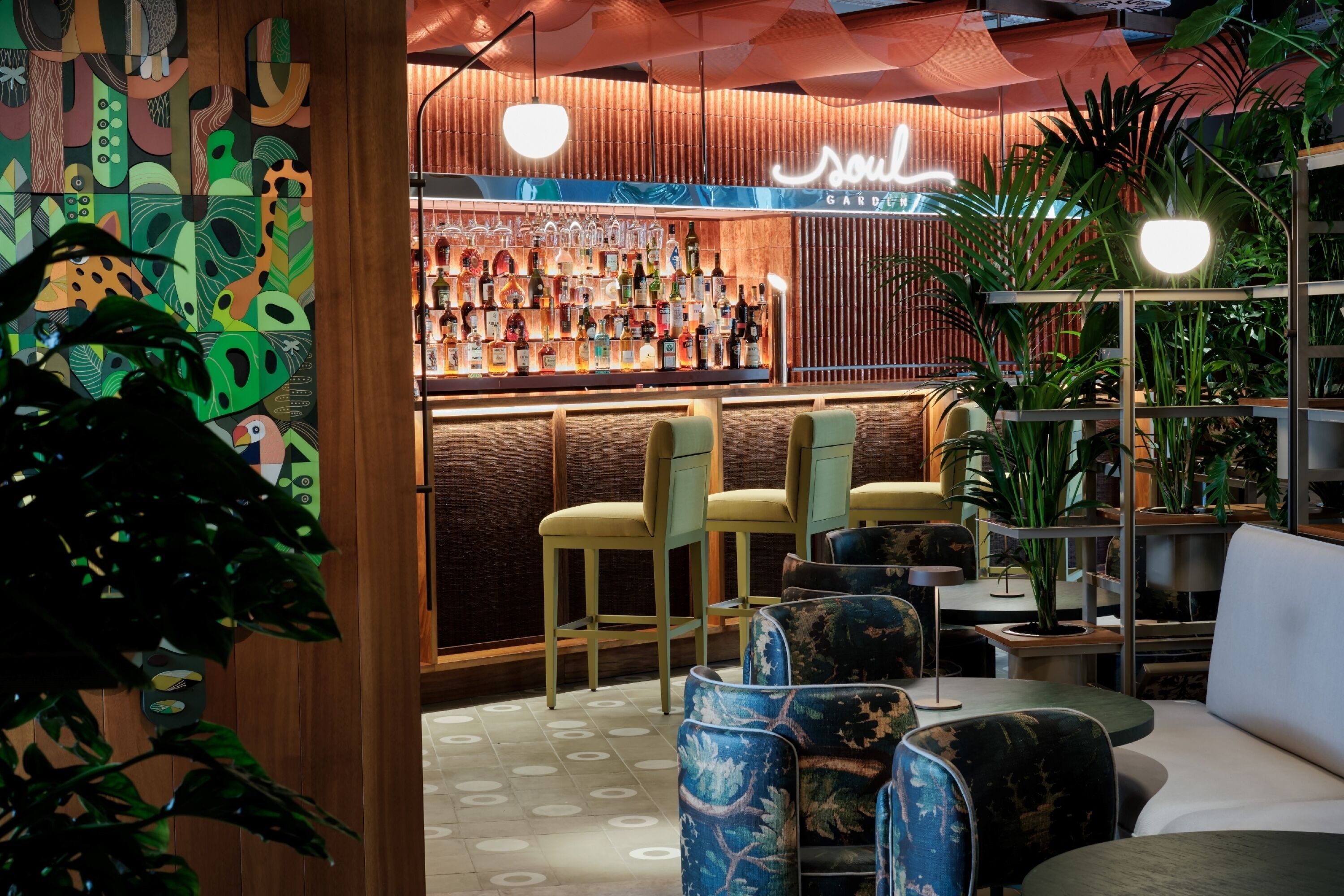 Un espace bar avec un mur en bois, des tabourets de bar et un panneau lumineux au néon.