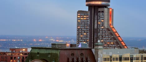 A high-rise building with a distinctive curved design and a lit tower.