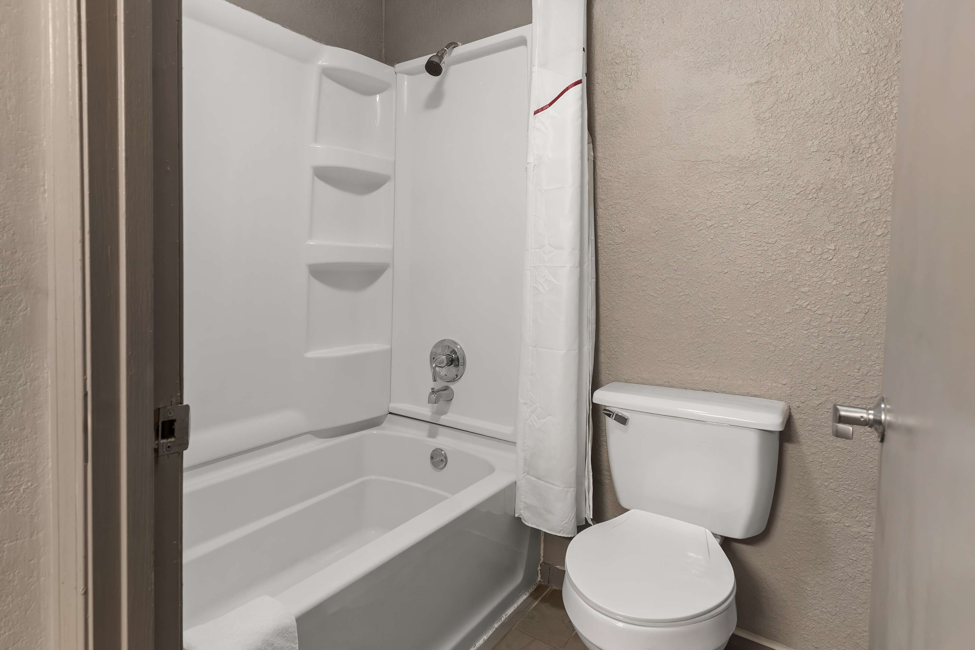 Une salle de bain avec une baignoire, des toilettes et un rideau de douche.