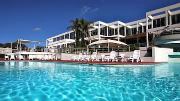 Una piscina al aire libre, sombrillas