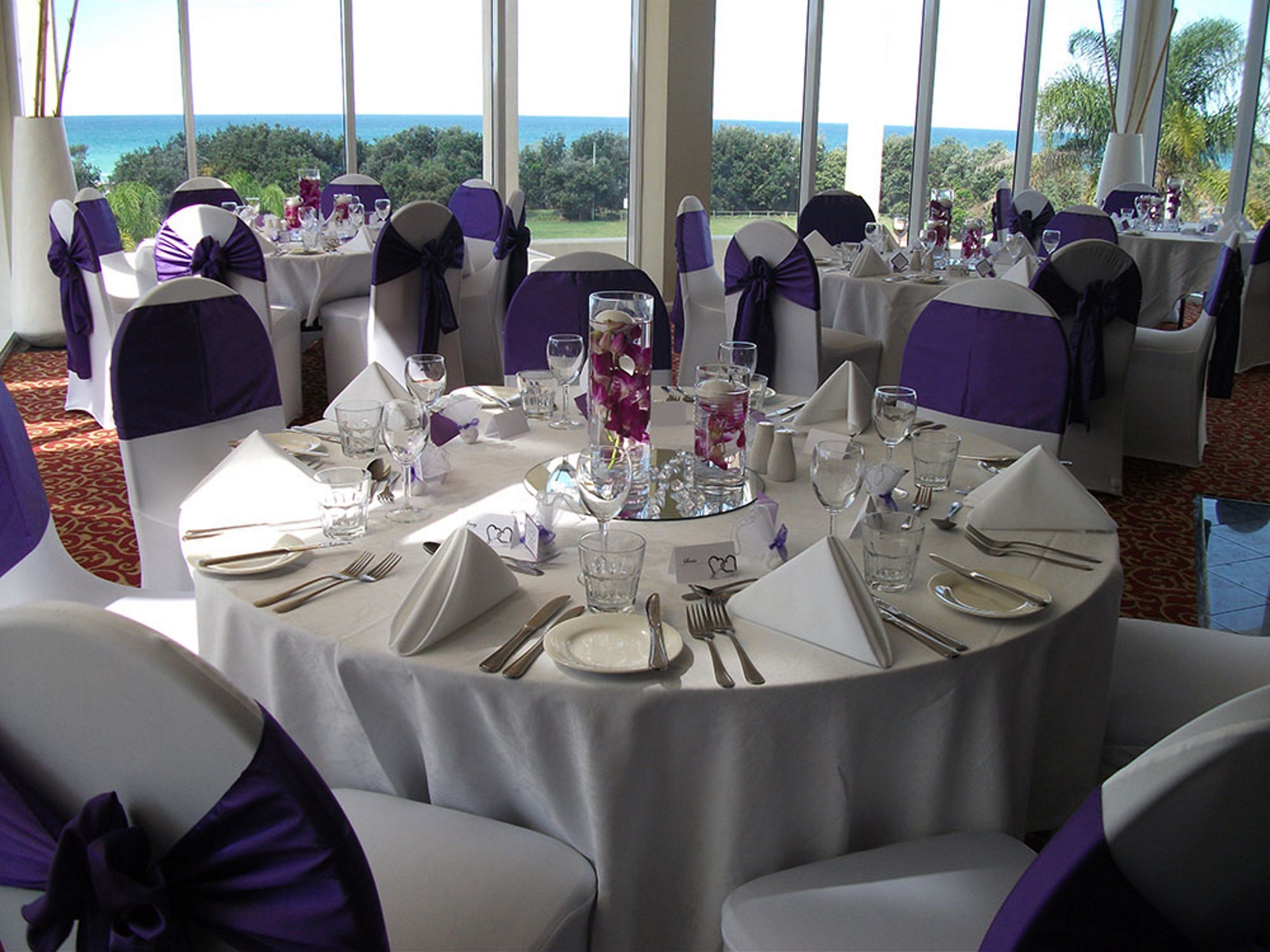 A round table set for a formal event with chairs and table settings, overlooking a scenic view.