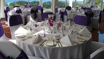 A round table set for a formal event with chairs and table settings, overlooking a scenic view.