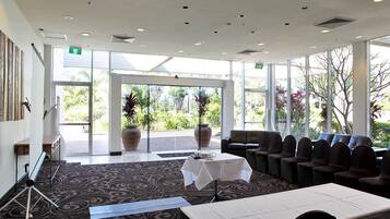 A spacious indoor area with a large window, a seating area with chairs, a table, and a bench.