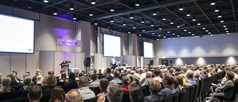 A conference room with rows of chairs facing a presentation area.