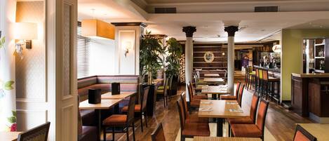 A restaurant with booths, tables, and a bar area.